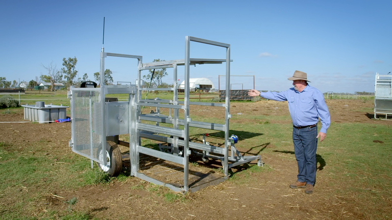 Farmer pokazuje na sustav za autonomno vaganje stoke Tru-Test WOW postavljen na pašnjaku